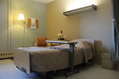 Private resident room with a bed and chair
