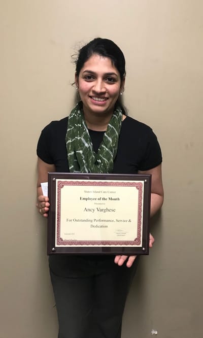 Employee of the Month holding a certificate