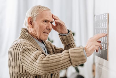 An elderly man focusing on a calendar