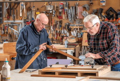Two men working on woodworking in a shop