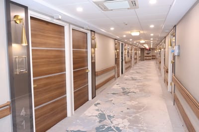 Brightly lit hallway with doors to resident rooms