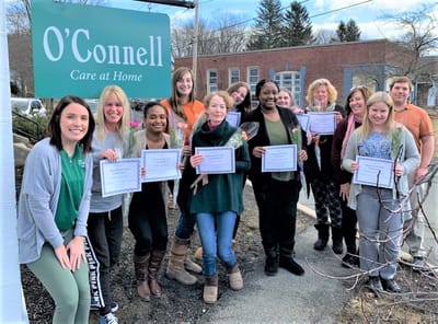 Staff members holding certificates outside the facility