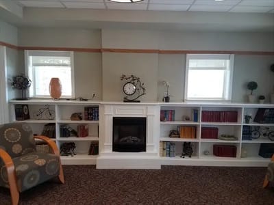 Cozy common area with fireplace and bookshelves