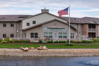 Exterior view of a senior living facility with a flag