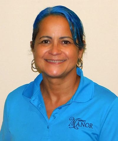 Staff member smiling in Osprey Manor polo shirt