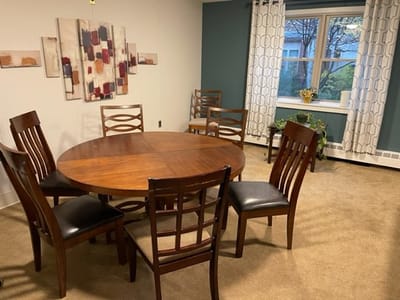 A common area with a round wooden table and chairs