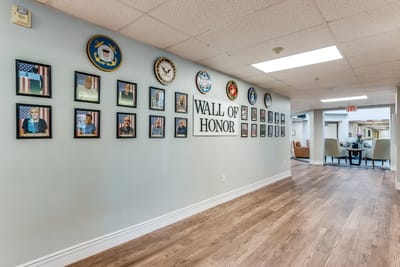 Hallway featuring a 'Wall of Honor' with framed portraits