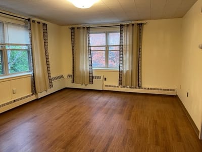 Empty resident room with warm lighting and wooden floor