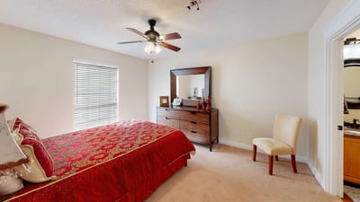 A cozy resident room with a red bedspread