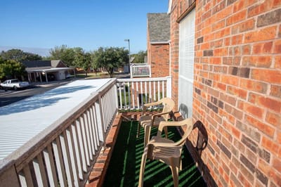 Outdoor balcony view with chairs and greenery