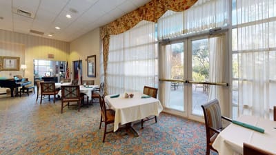 Dining room with tables and chairs, large windows