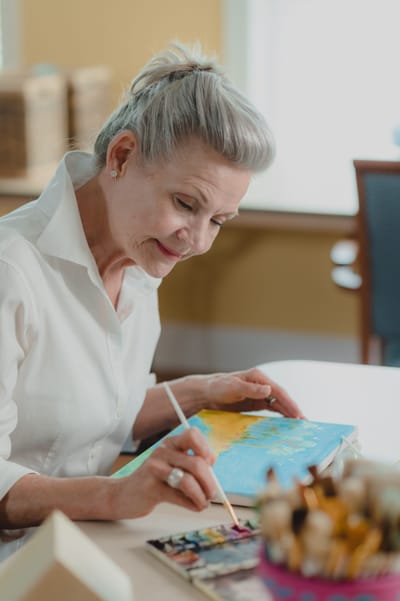 Resident engaged in painting activity indoors