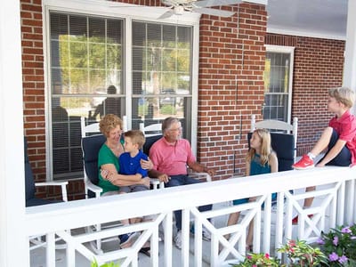 Family visiting residents on a porch