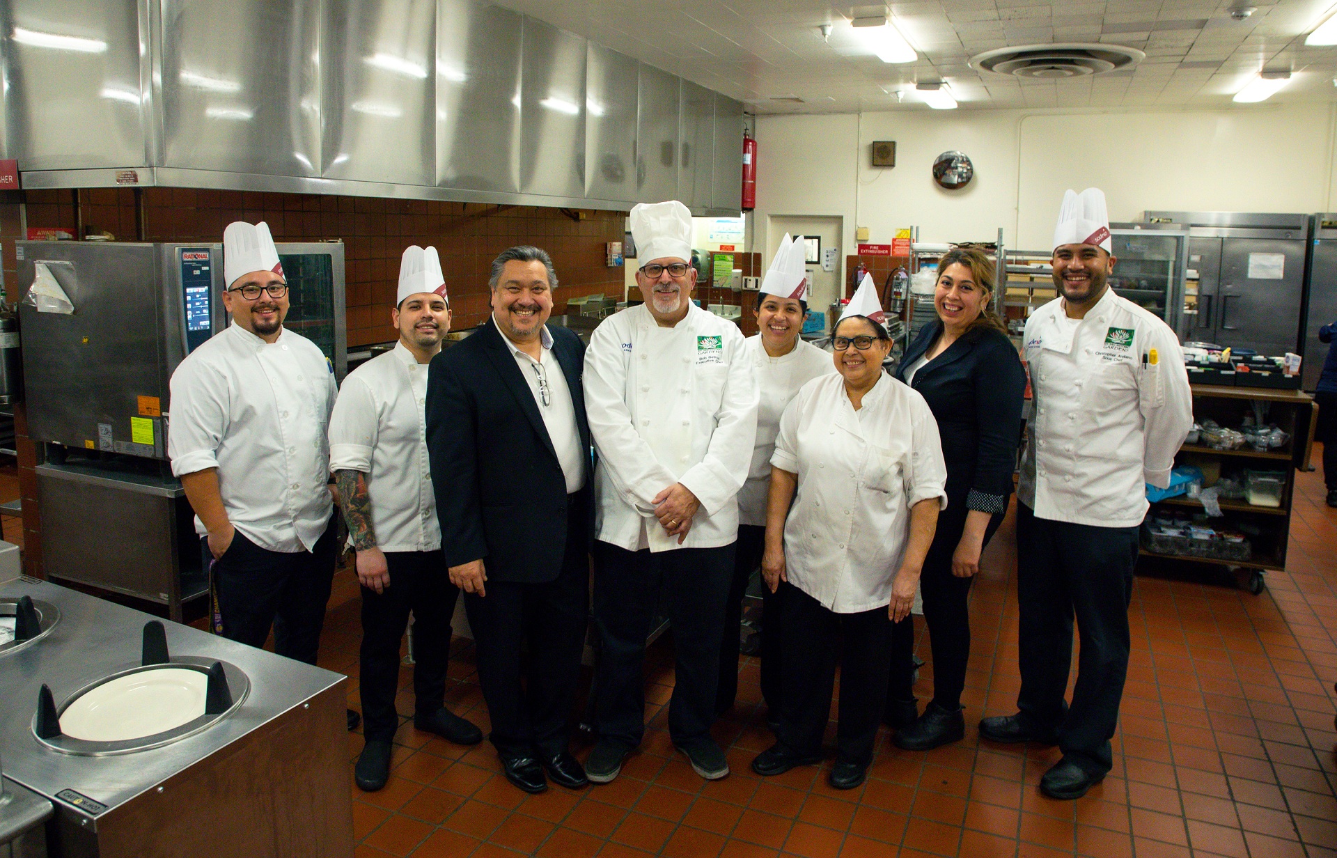 Kitchen staff posing together in a meal preparation area