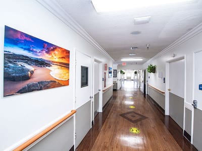 Hallway with artwork and smooth wooden flooring