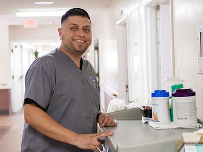 Staff member smiling in a facility hallway