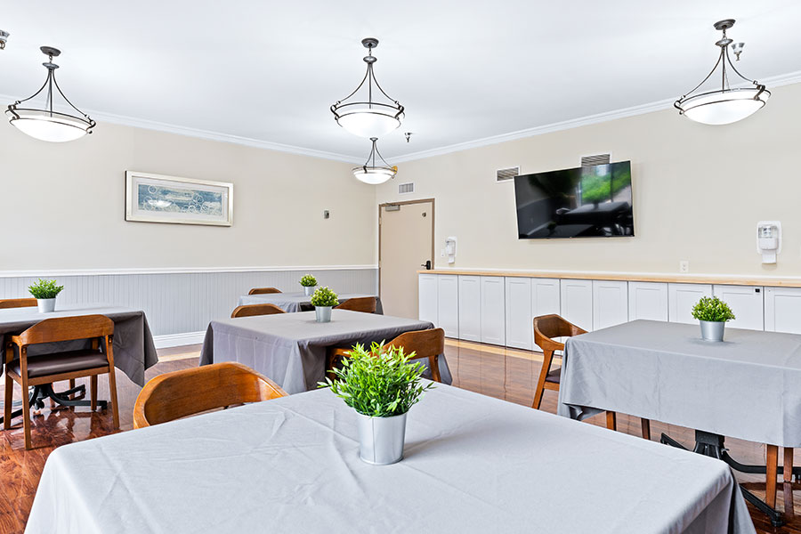 Bright common area with tables and chairs for residents