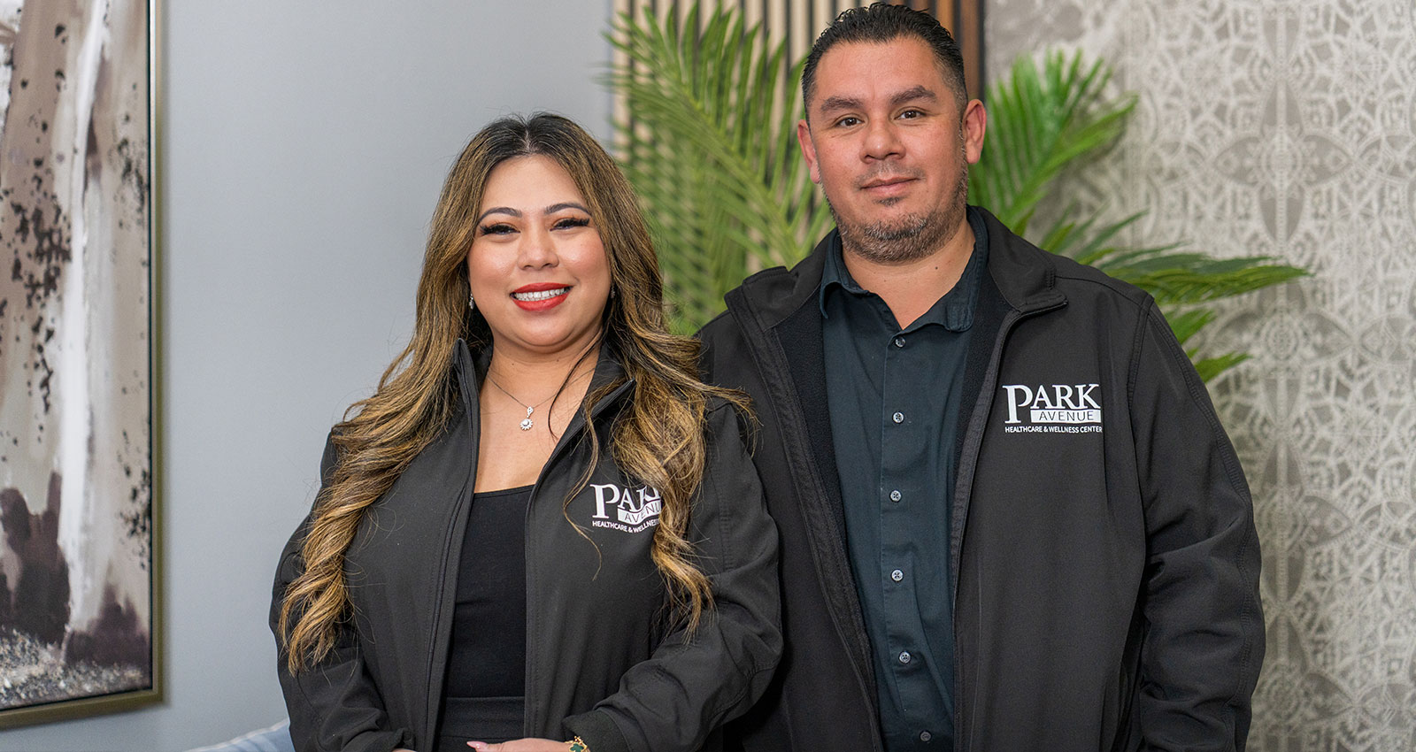 Two staff members in branded jackets indoors