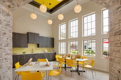 Bright interior common area with yellow chairs and large windows