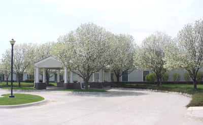 Entrance of Prairie Village Retirement Center surrounded by blooming trees