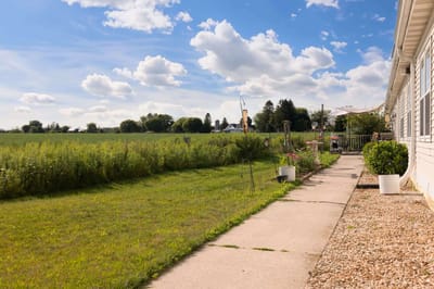 Pathway leading through open space with clouds above