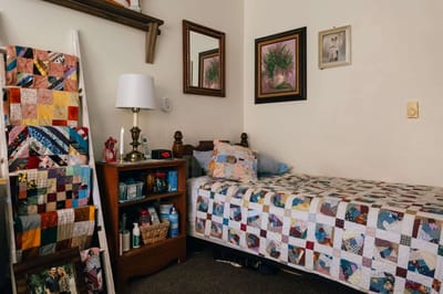 Cozy resident room with quilted bedding and personal decor