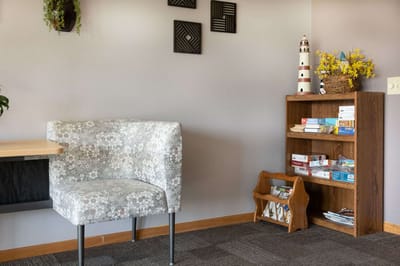 Cozy corner of a common area with a chair and bookshelf