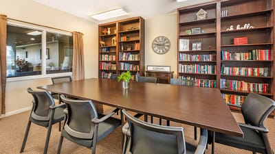 Well-furnished common area with bookshelves and a large table
