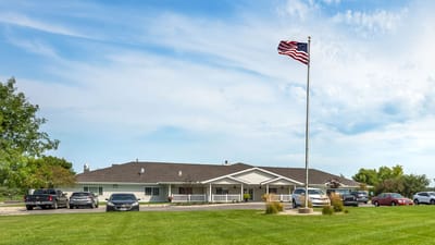 Exterior view of a senior living facility with flag
