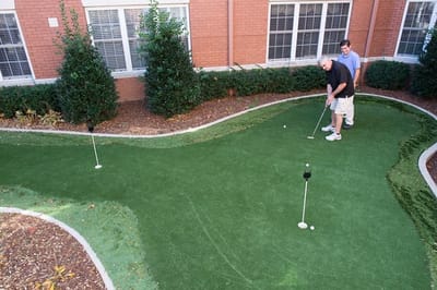 Residents playing mini-golf in a landscaped area