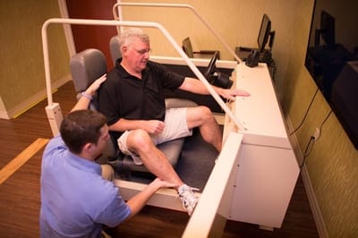 Therapist assisting a resident with exercise equipment