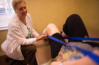 Health professional assisting a resident with therapy