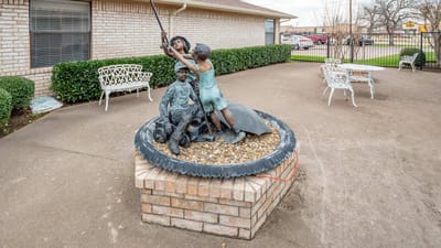Bronze statue of a child and adult outdoors