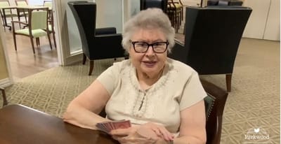 Senior resident playing cards in a common area