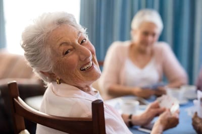 Parkwood Independent Living, independent living in Bedford, TX — Smiling senior woman playing cards with a friend