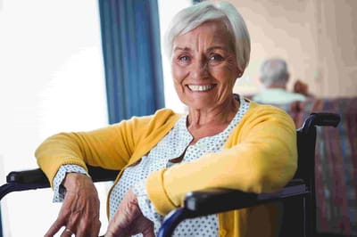 Parkwood Independent Living, independent living in Bedford, TX — Smiling senior woman in a wheelchair wearing a yellow sweater