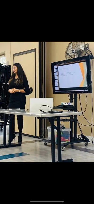 Presenter speaking in a meeting room setting.