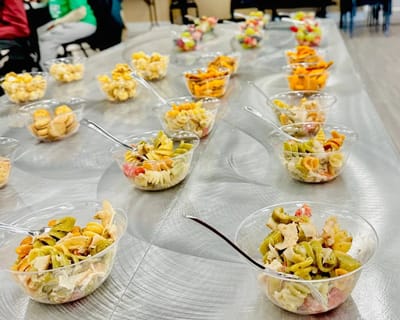 Colorful salads served in plastic bowls on a table.