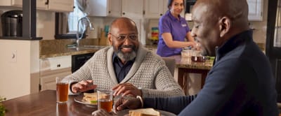 Residents enjoying lunch with a caregiver