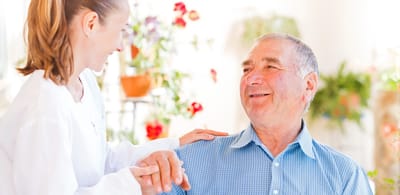Caregiver interacting with an elderly man indoors