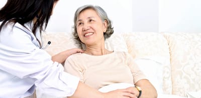 Caregiver interacts with a smiling senior resident.