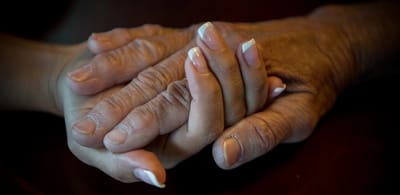 Two hands gently holding each other