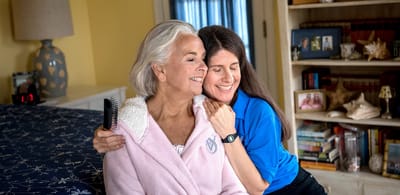 A caregiver and a resident share a warm moment.