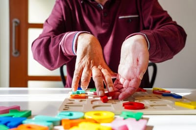 Accent Care – Portland, hospice care in Portland, OR — Hands of a senior assembling colorful alphabet puzzle pieces