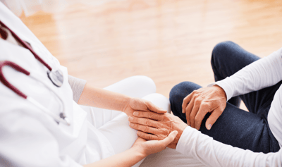 Healthcare professional holding hands of a senior