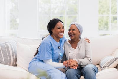 Caregiver and resident sharing a joyful moment indoors.
