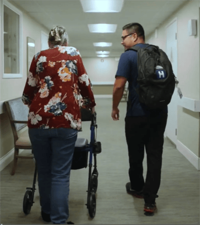 Staff assisting a resident in a hallway