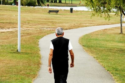 Senior walking along a path in a park