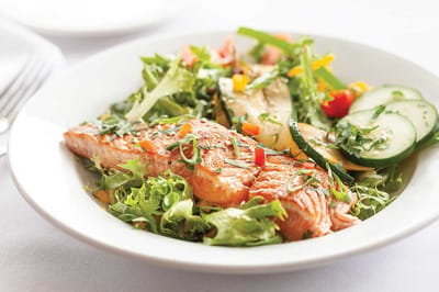 Healthy salmon dish with salad and vegetables.