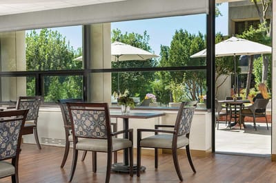 Bright common area with dining tables and outdoor view.